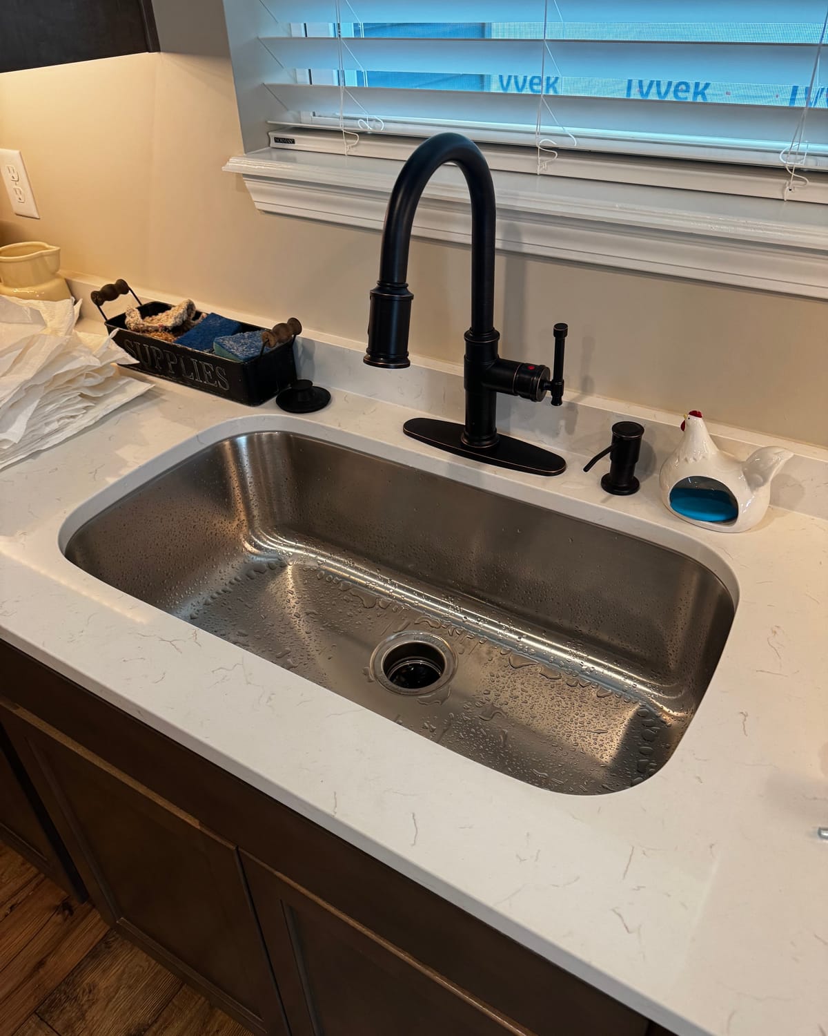 Stainless undermount sink and matte black faucet installed in a kitchen
