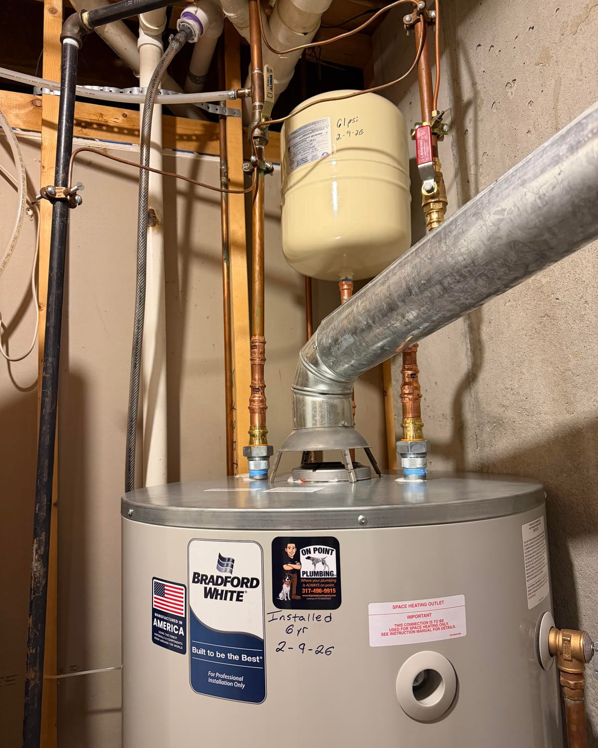 Water heater with On Point Plumbing sticker and install date