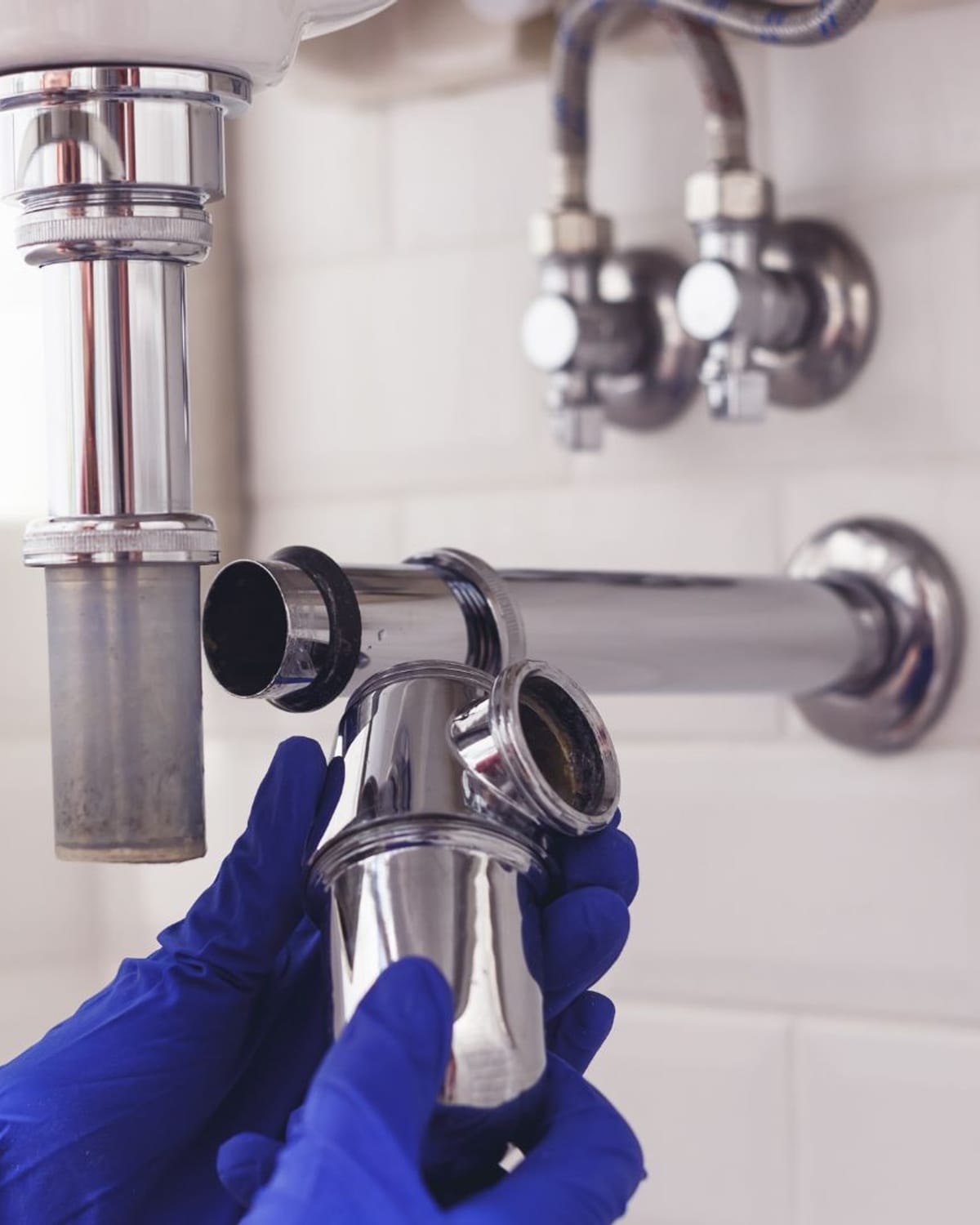 Plumber removing a failed drain trap during a repair visit