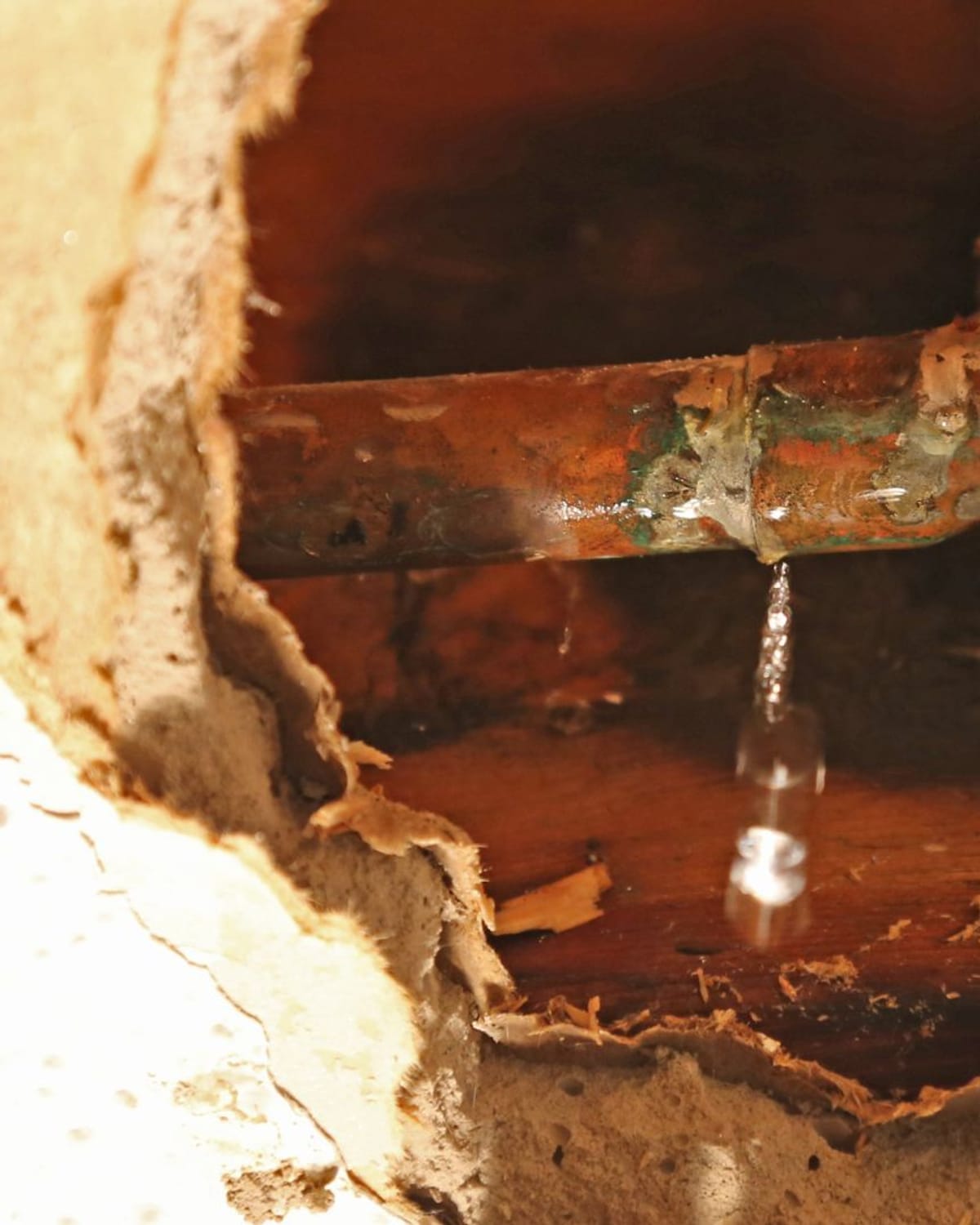 Corroded pipe leaking through a ceiling before repair