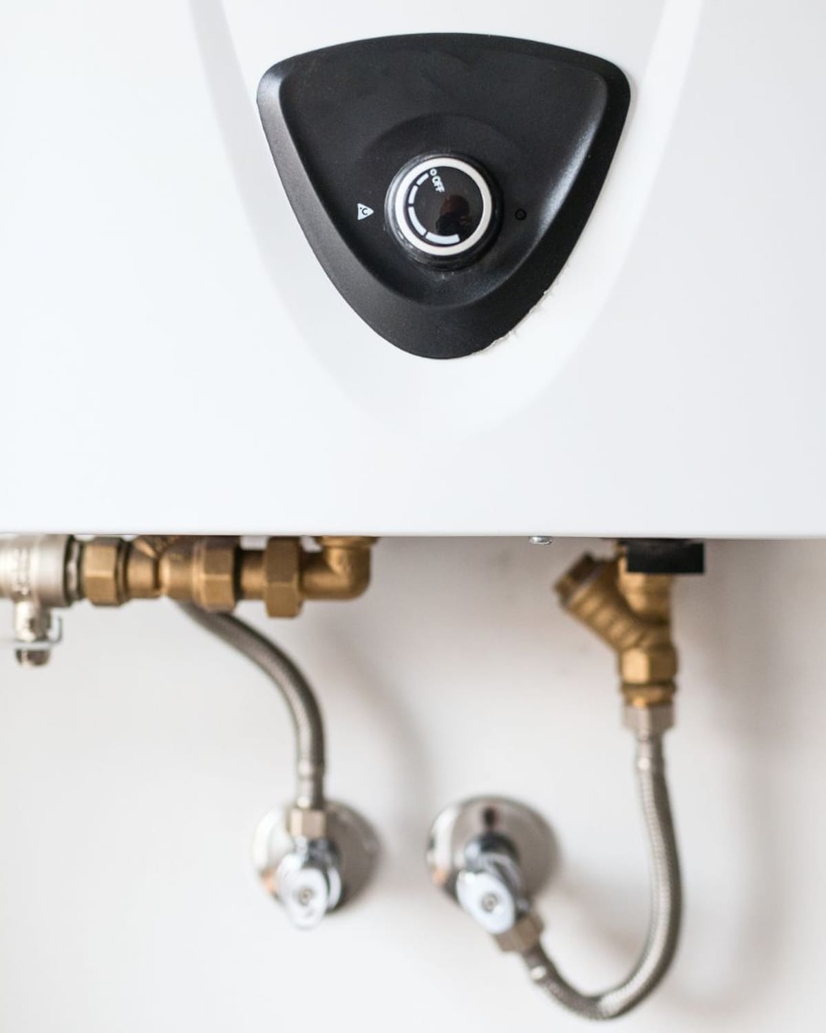 Compact wall-mounted tankless heater with neat supply connections