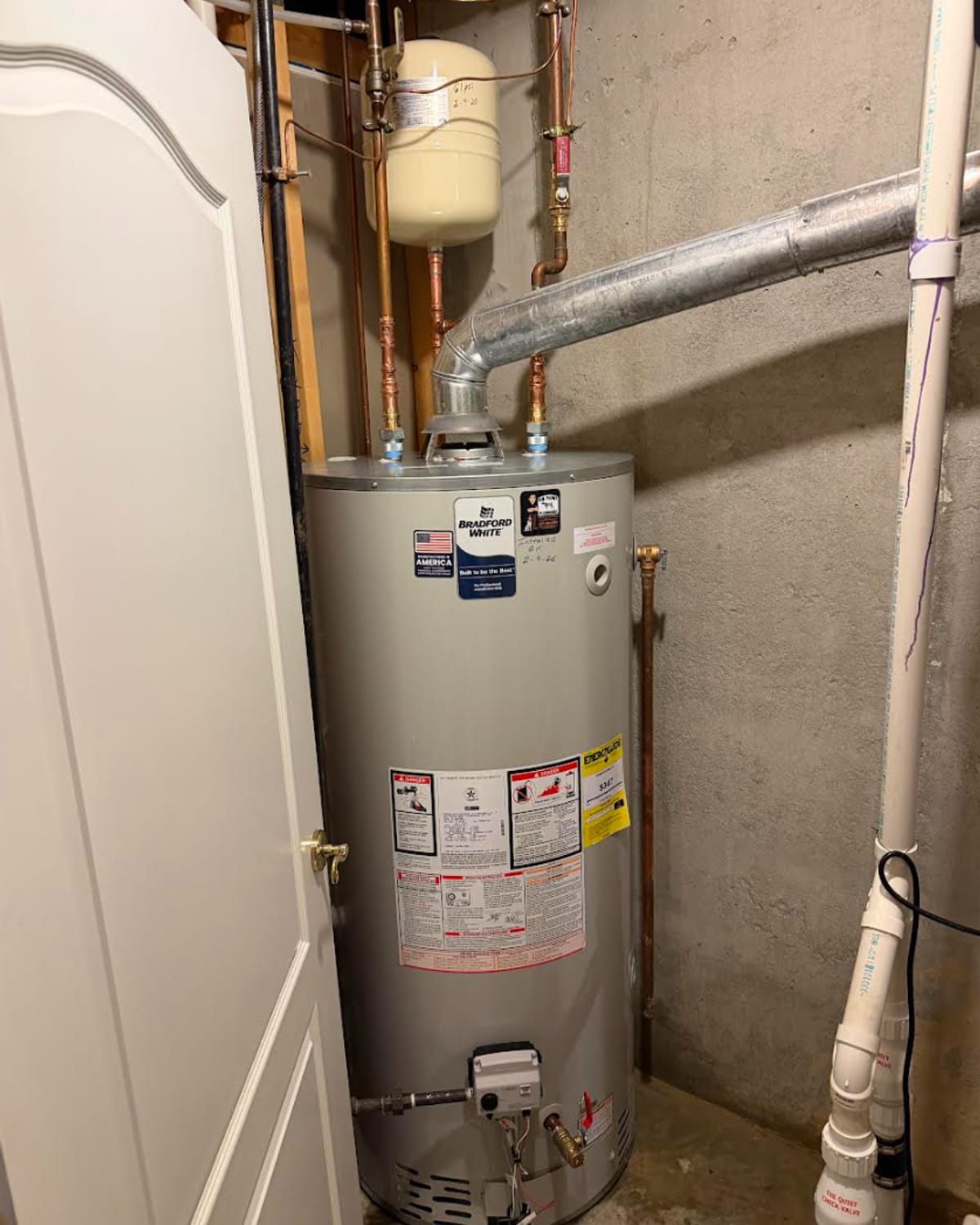 Aging water heater tank awaiting replacement in a Greenwood basement