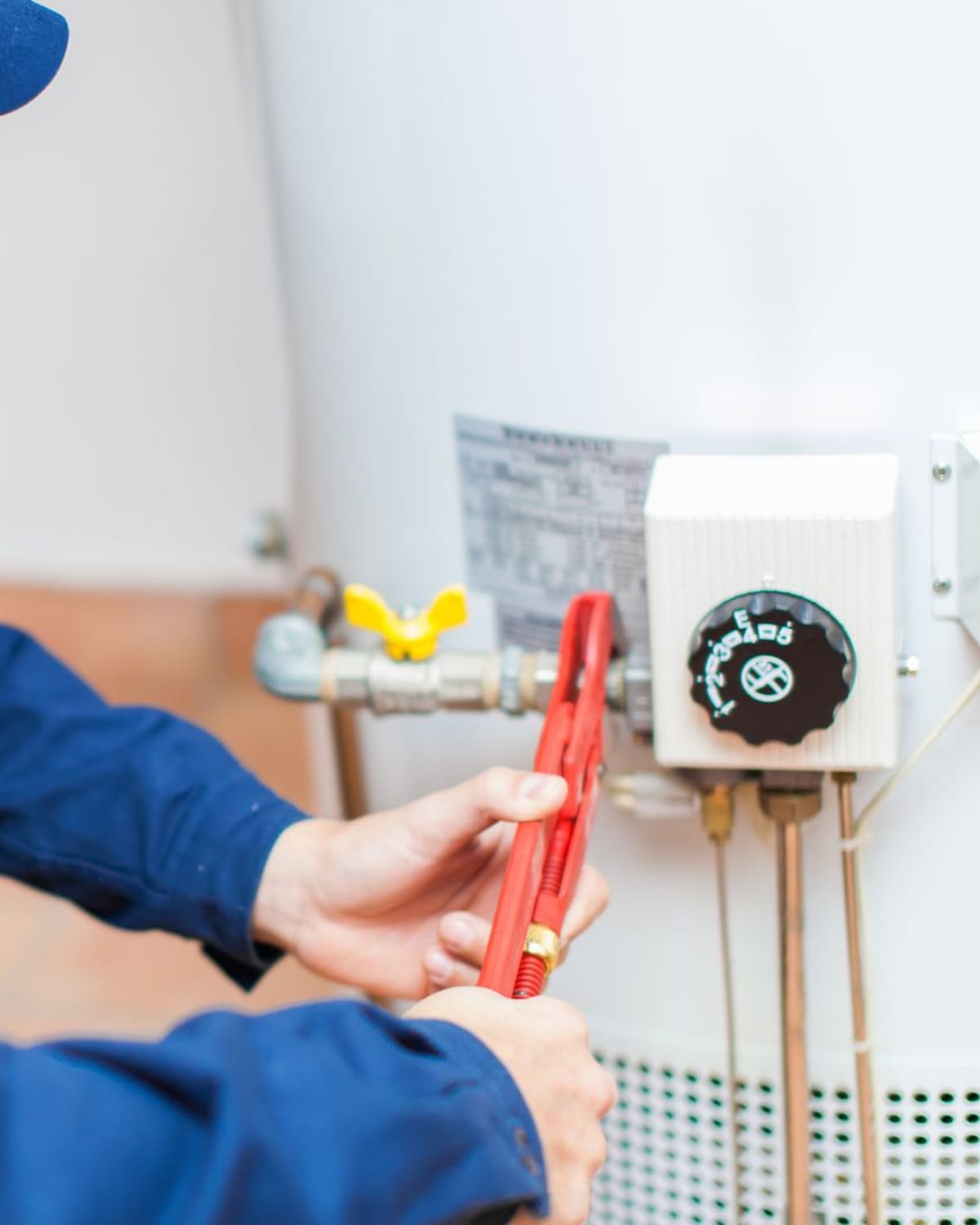 Plumber adjusting the gas control valve on a residential water heater