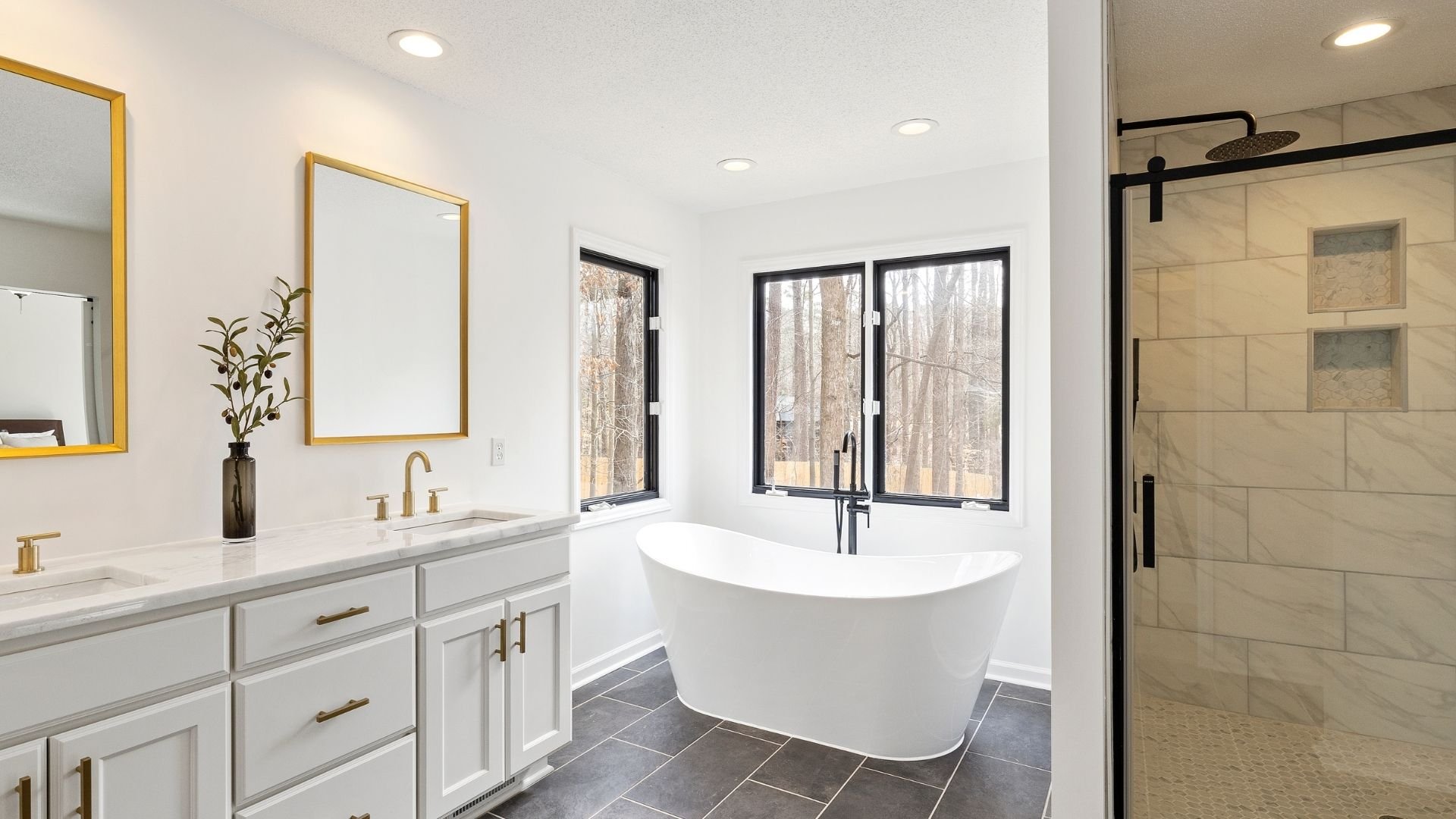 Modern bathroom with freestanding tub, marble shower, and elegant plumbing fixtures