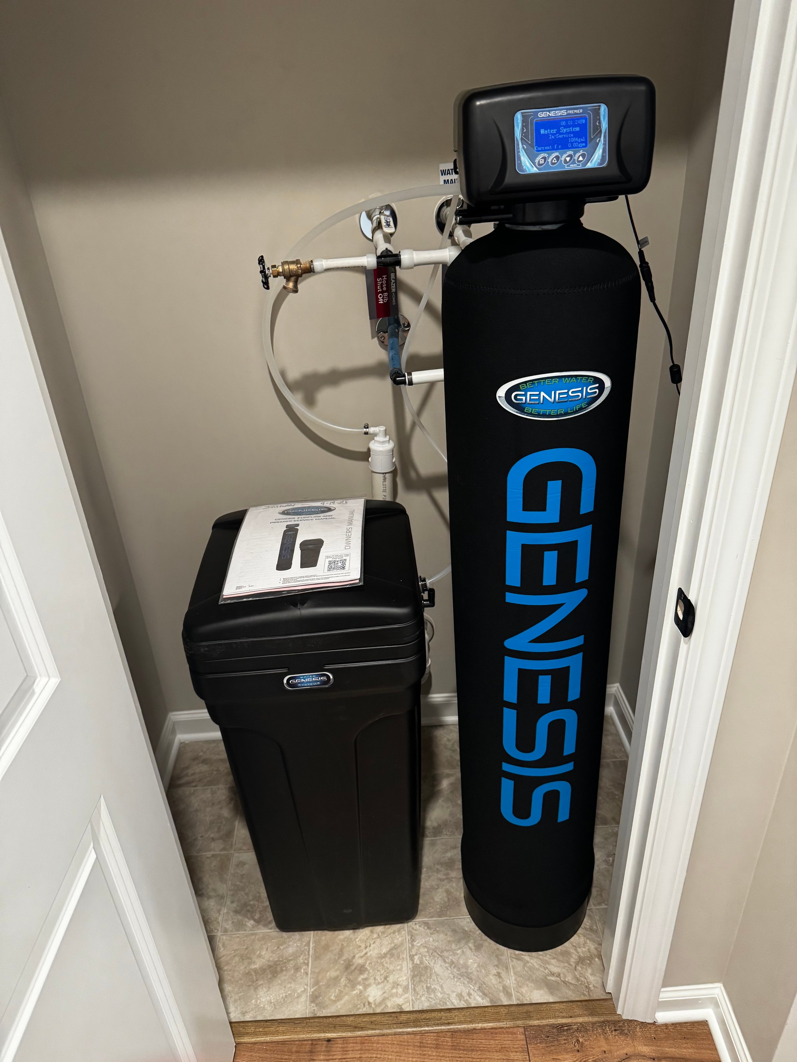 Genesis water softener system installed in home plumbing utility closet