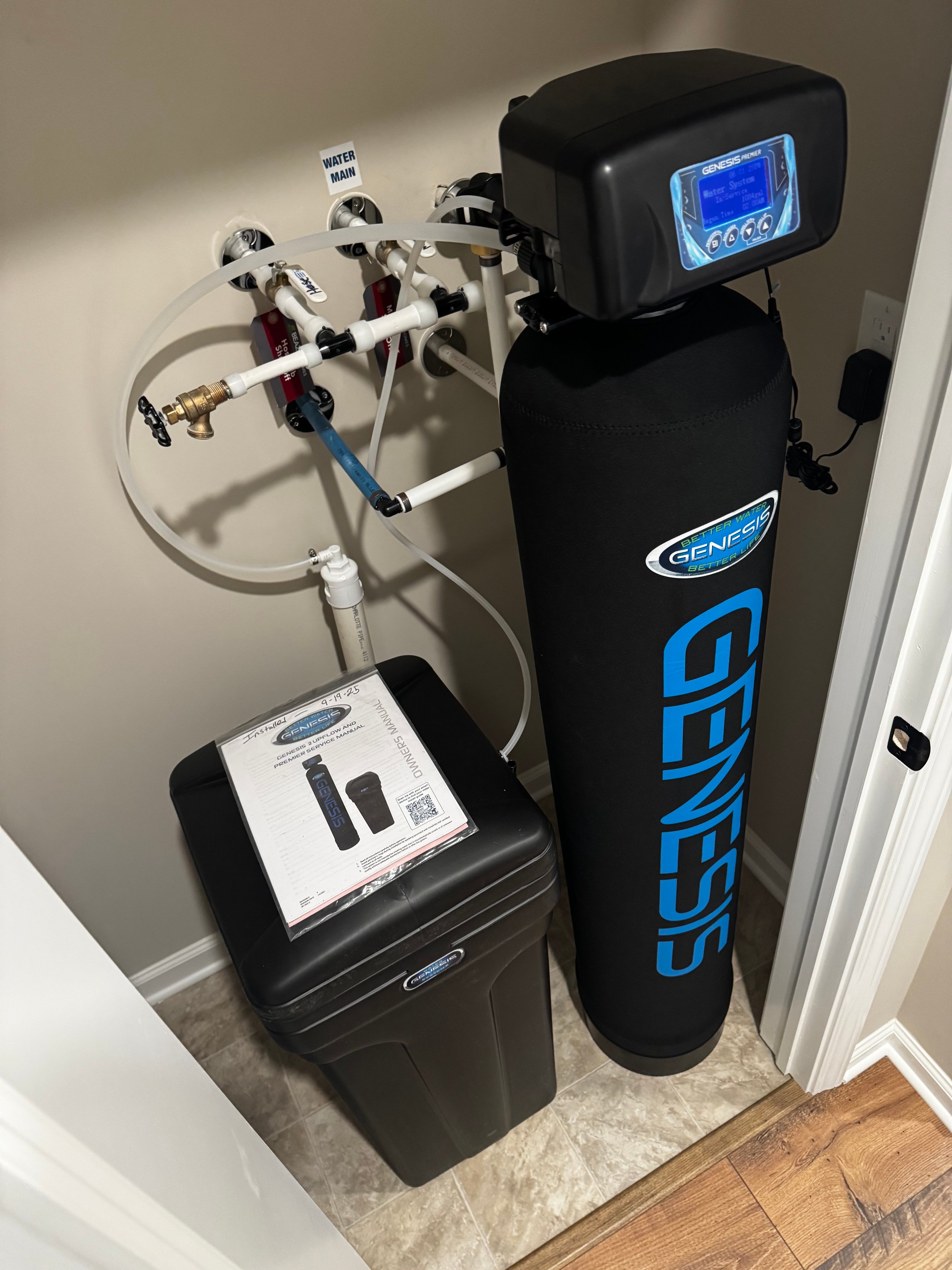 Genesis water softener system with plumbing connections in home utility area