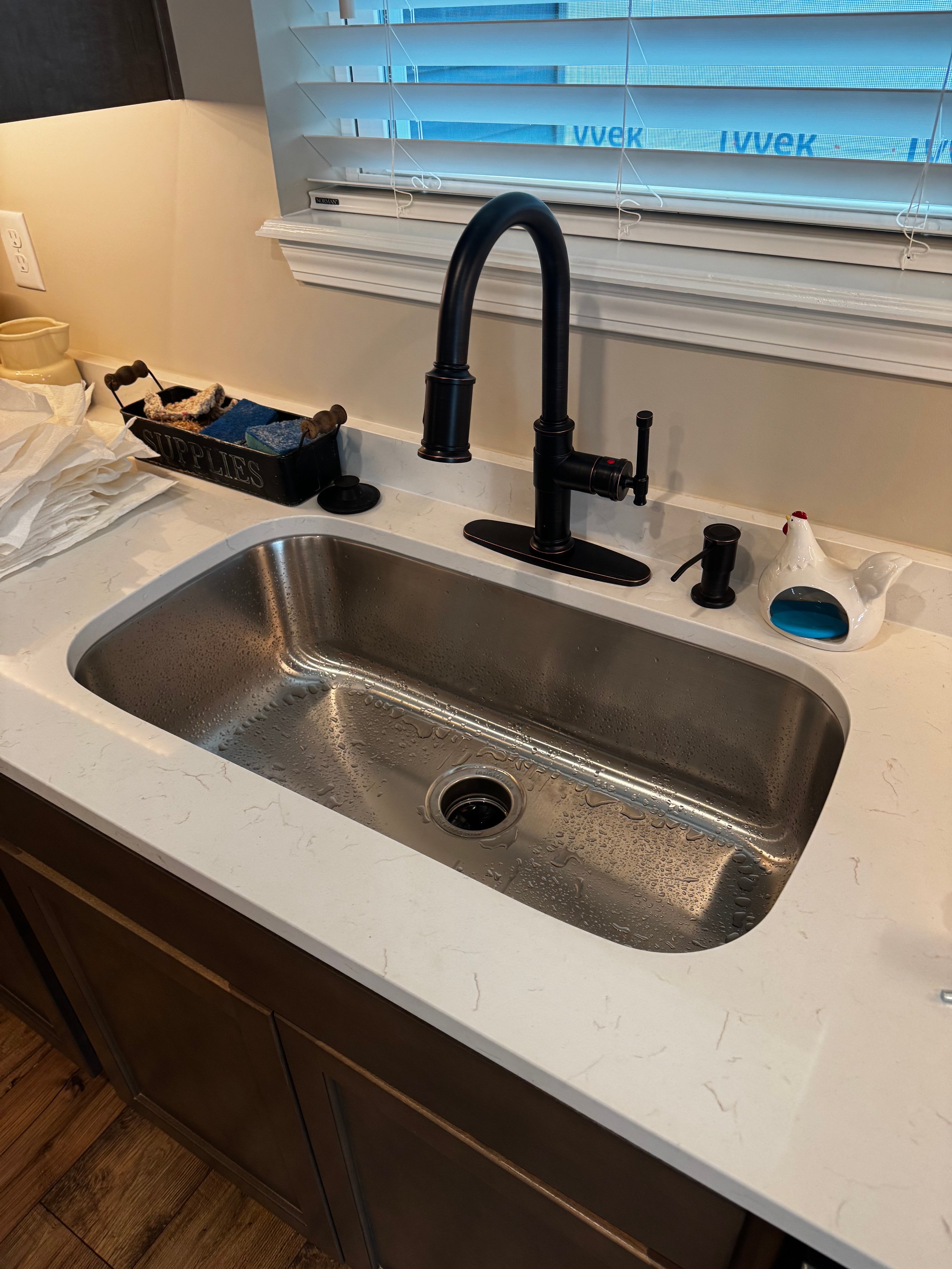 Black faucet and stainless steel sink with modern plumbing fixtures