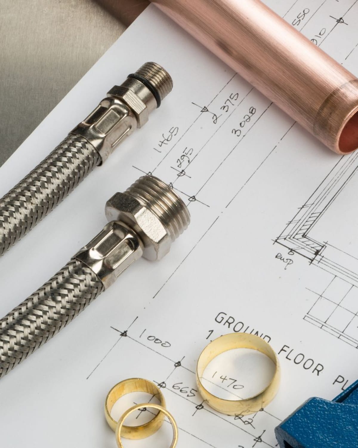 Plumbing fittings and tools laid out over a project plan